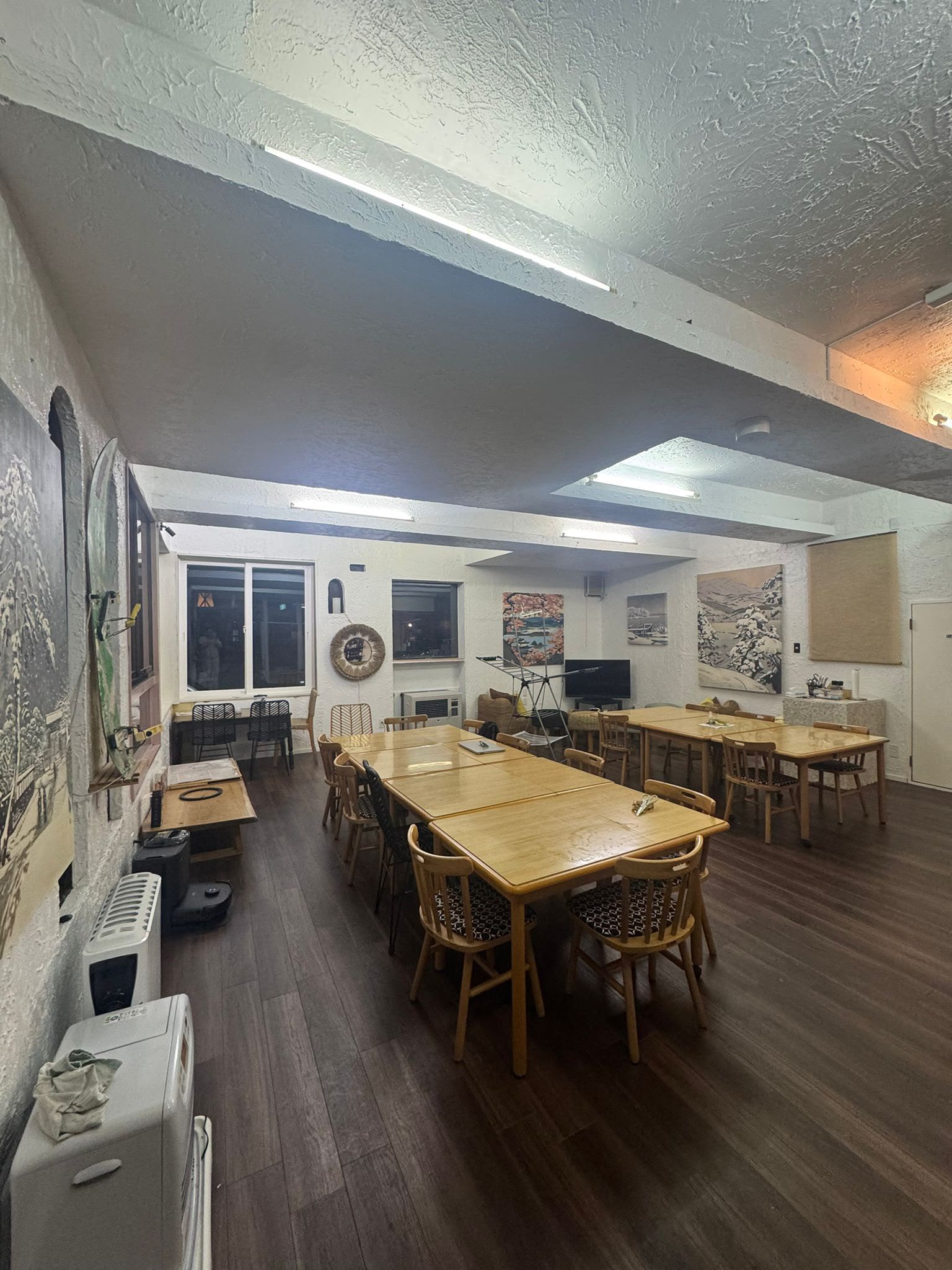 Communal dining tables with woven chairs and wall art