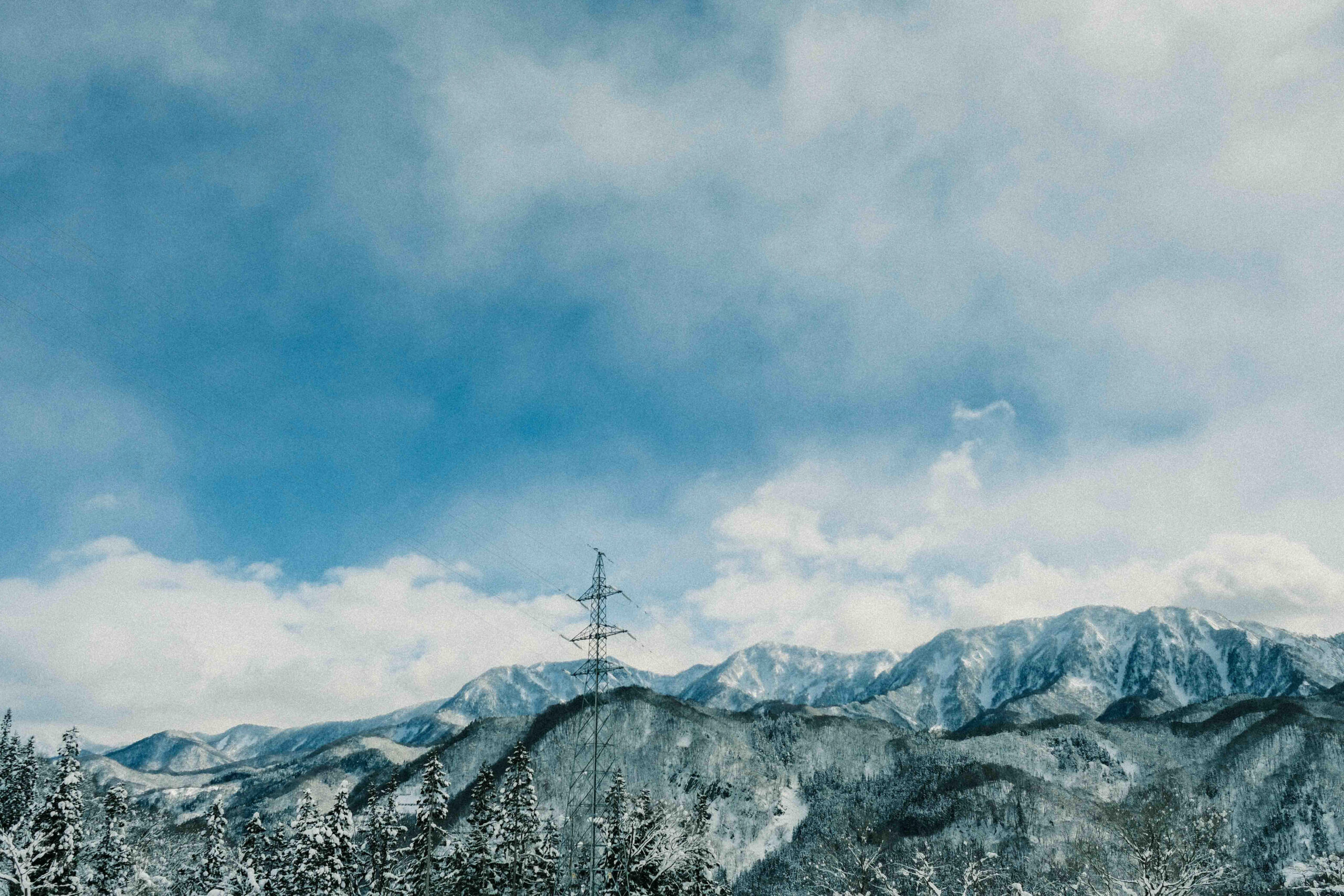 Snow-covered mountain range with dramatic clouds near Myoko