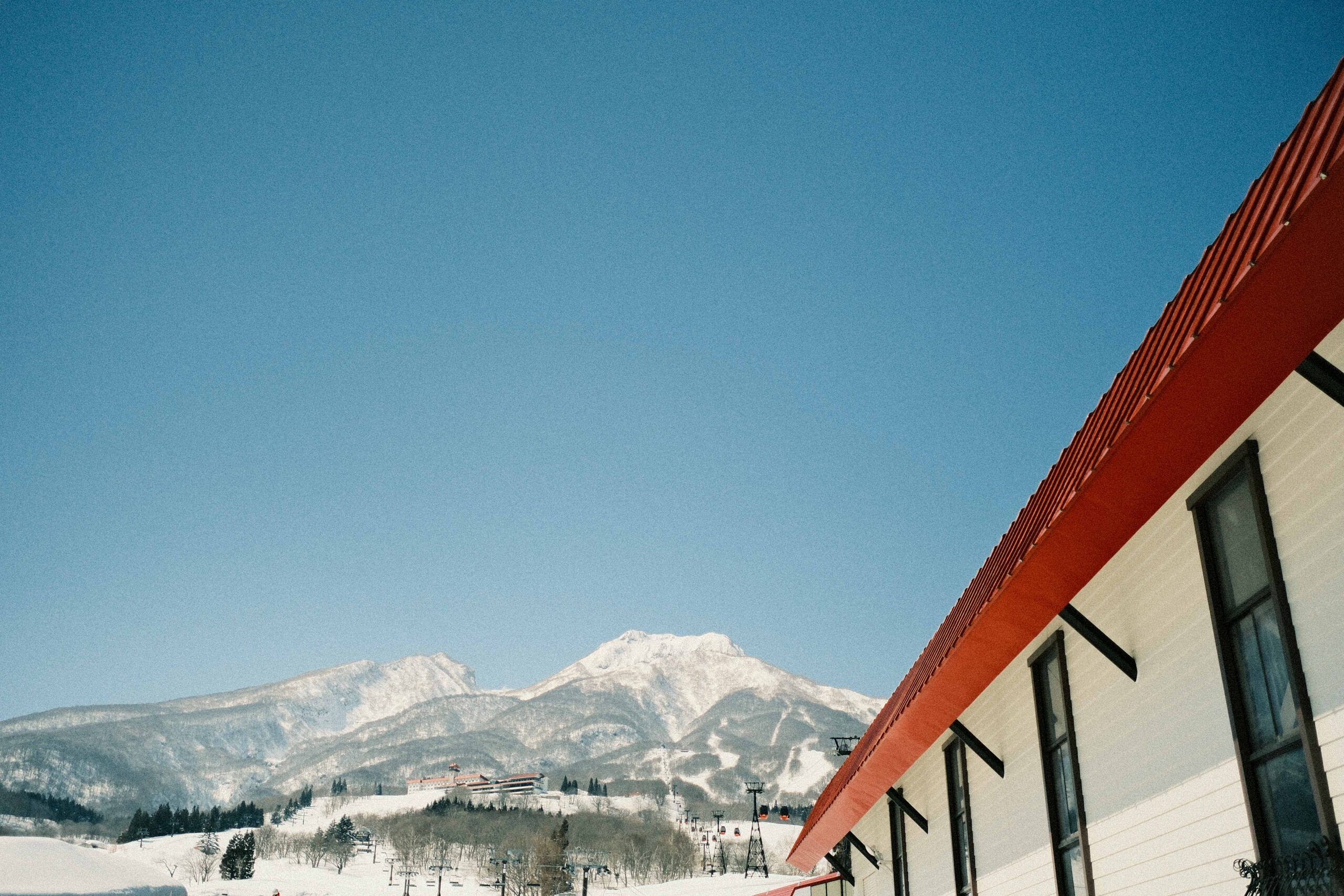 Mt Myoko on a clear bluebird day with ski resort and red-roofed building