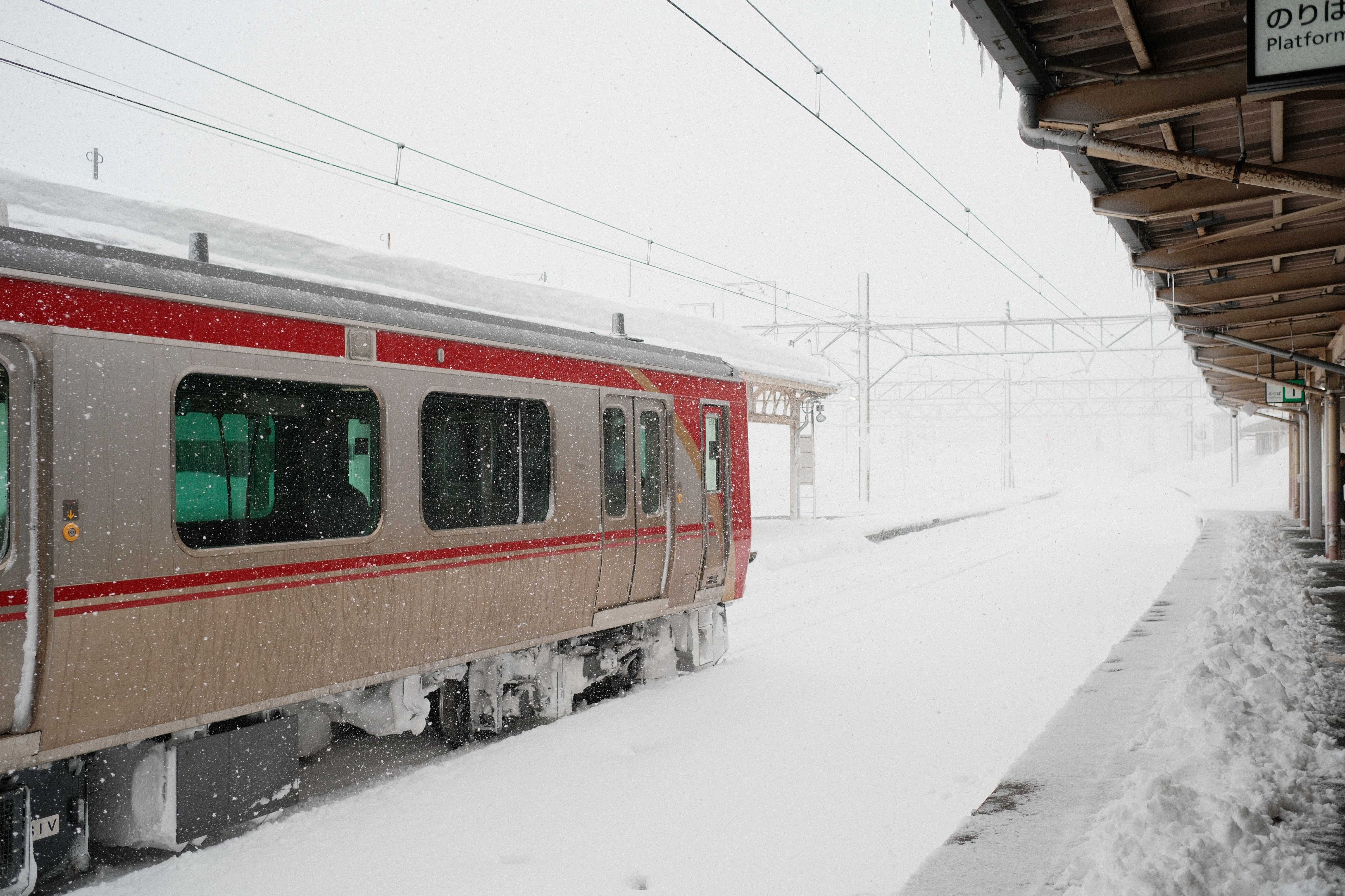 Train arriving at a snow-covered platform in Myoko
